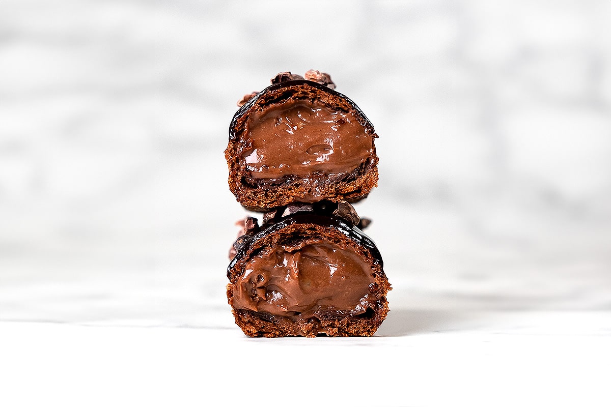 découpe d'un éclair au chocolat sur fond blanc