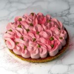 tarte pistache framboise posée sur un fond de marbre